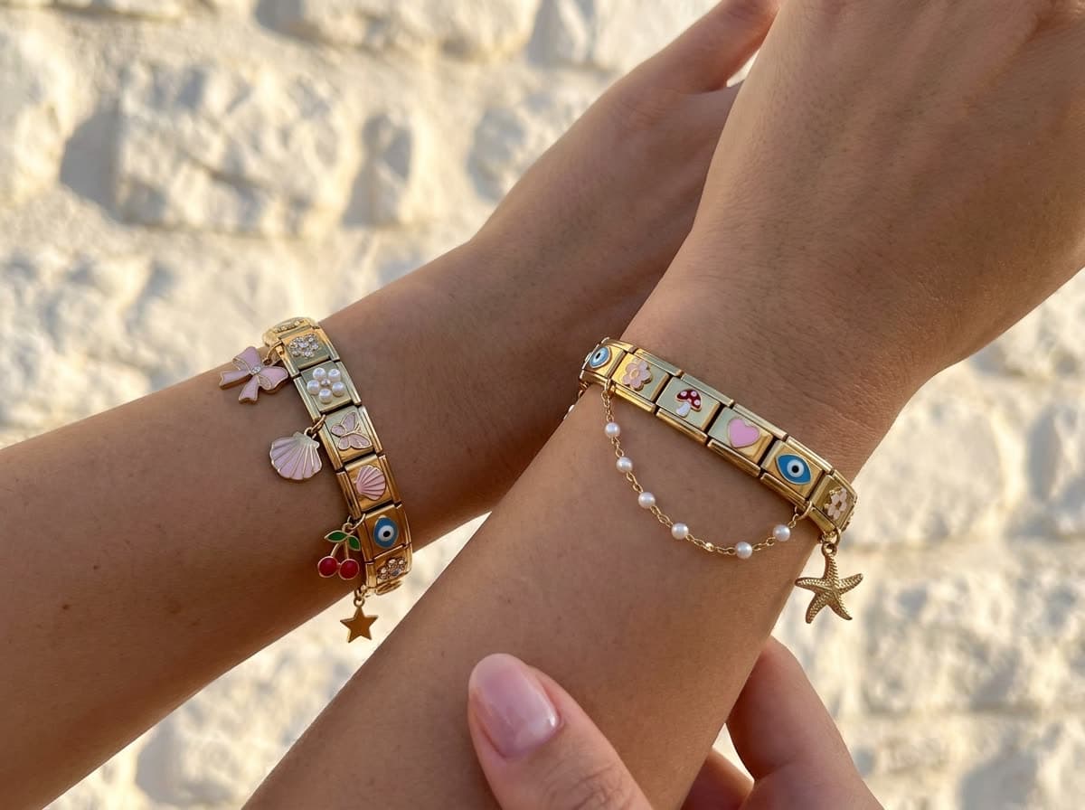 Two women's wrists side by side against a sunlit wall, each wearing a charm bracelet